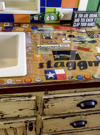 They designed a “scrapbook countertop” where they used acrylic to freeze various sentimental items such as matchbooks, bottle caps, photos, maps and patches into the counter. Photo by Danny Fulgencio