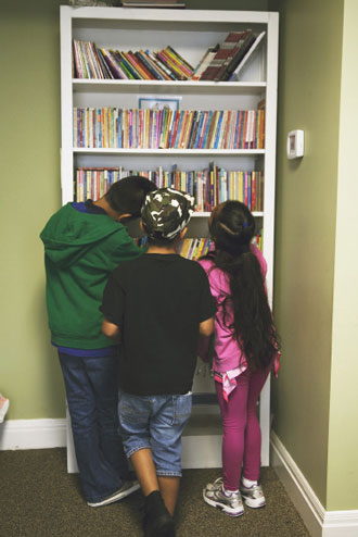 Kids choose books in the library at Bishop’s Camp. Photo by Desiree Espada