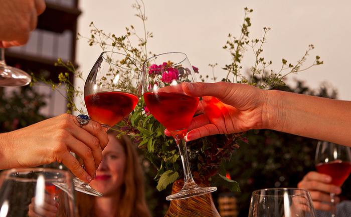 Two people clink wine glasses.