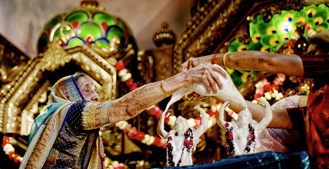 Worshippers perform ceremonial bathing of the Krishna deities in yogurt. Hindus and members of its Hare Krishna denomination believe the religious statues represent God: Photos by Hilary Schleier