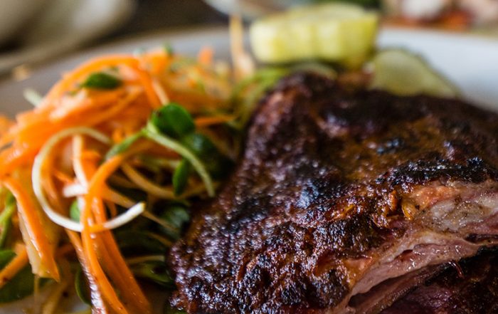 The smoked lamb brisket is served alongside parsnip slaw and lathered under a sweet onion puree. (Photo by Rasy Ran)