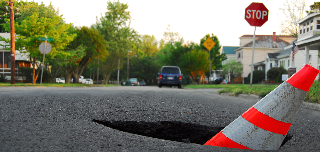 deep pothole with caution cone