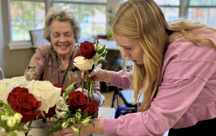 Juliette Fowler staff member demonstrates flower arranging for a resident before residents make their own arrangement. Photo courtesy of Juliette Fowler.