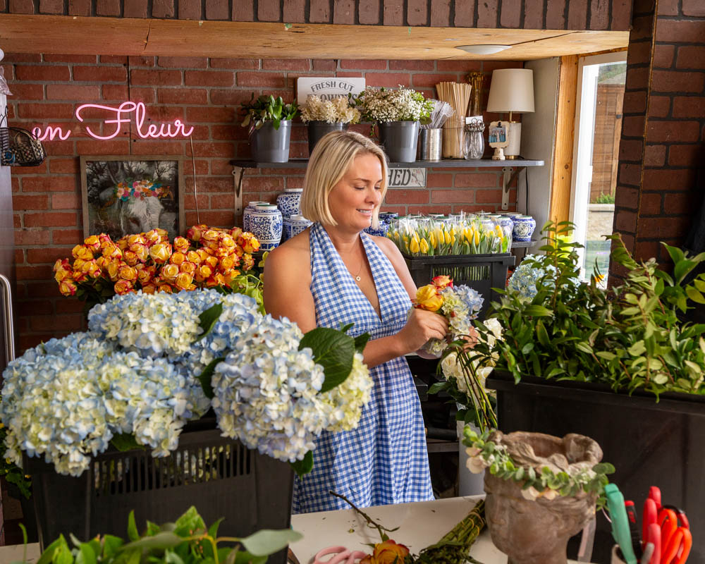 Kristee Rouse of En Fluer is surrounded by flower. Photo by Yuvie Styles