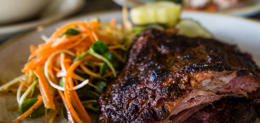 The smoked lamb brisket is served alongside parsnip slaw and lathered under a sweet onion puree. (Photo by Rasy Ran)