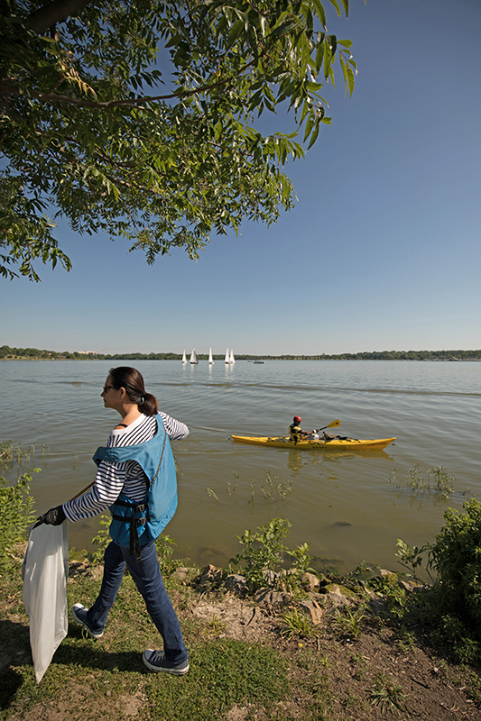 Florence Mellon moves alongside the shore while a kayaker moves in the opposite direction, combing alongside White Rock Lake’s borders for litter. (Photo by Rasy Ran)